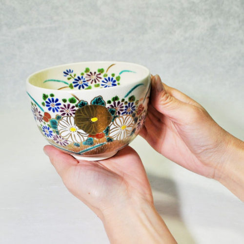 抹茶碗菊花を女性が両手で持つ画像